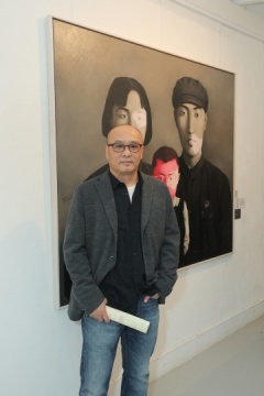 张晓刚在其参展作品《大家庭:血缘系列》前合影
张晓刚在其参展作品《大家庭:血缘系列》前合影