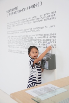 展览现场，袁运甫和谢徳庆的《一年行为表演1980-1981（等待打卡）》，一位小观众通过打卡记录自己到场时间。
