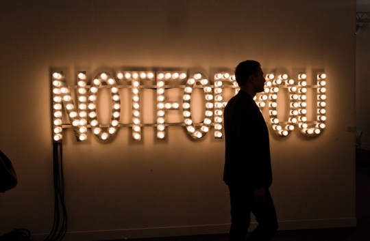 A visitor wanders by a Not For You neon at Frieze London.Photograph Sarah Lee/the Guardian. A visitor wanders by a Not For You neon at Frieze London.Photograph Sarah Lee/the Guardian.