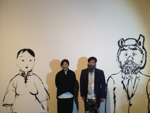 参展艺术家李津、靳卫红在现场创作的肖像前合影
