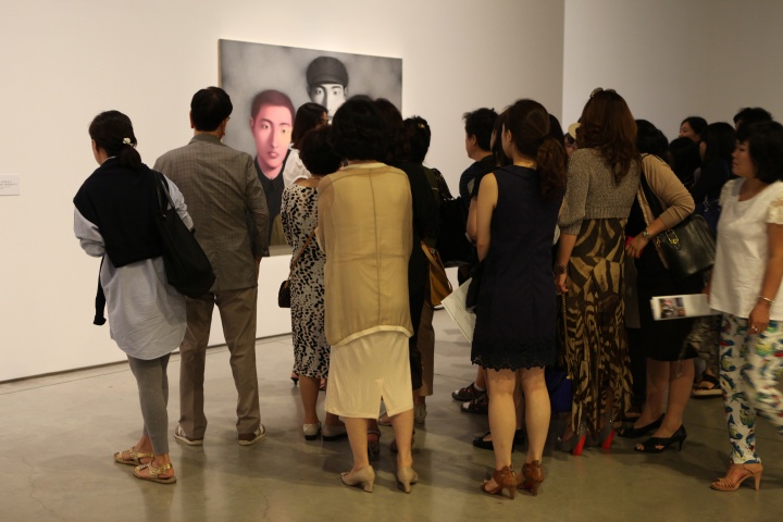 聚拢在张晓刚作品前的人们
聚拢在张晓刚作品前的人们