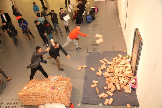 2014年11月，“异景-撞门：张树功、胡雪冰联展”展览现场，观众参与《敲门1000次》作品行为
