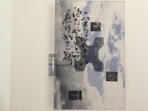 贾小丁作品《虚空间隙》，以钢铁固定在墙面的装置作品，这一件画面上的书法为《心经》，汽车元素，另一件的画面是多芬香皂的借用
