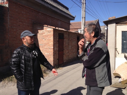 艺术家、村长靳勒在西芦城村与村民交谈
