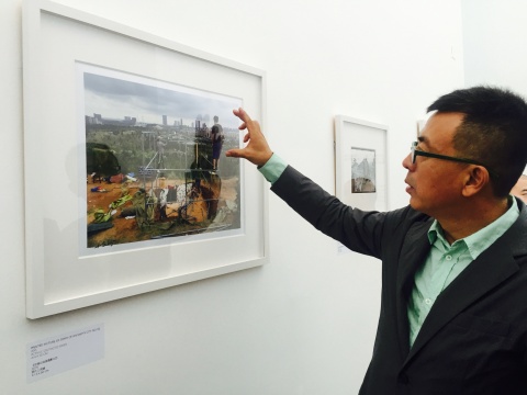 刘小东在一幅作品前介绍，画面中的马囚禁于钢管中，隐喻都市化进程中的战争、人类对现实的反思
