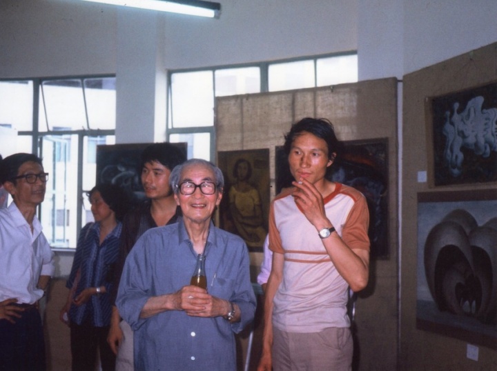 1985年6月，首届“新具像画展”现场，毛旭辉与前辈关良先生在展厅合影。背景是毛旭辉作品

