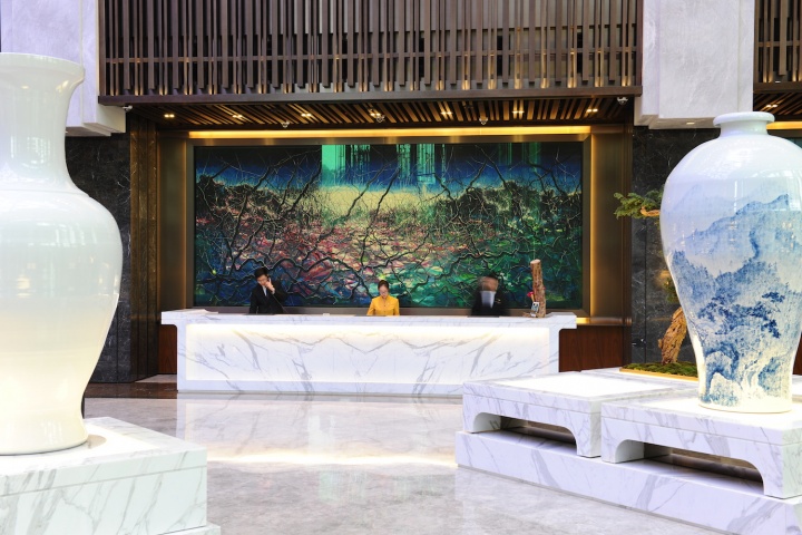 酒店大堂前台区域是曾梵志大尺幅的乱笔风景油画《风景2014》
