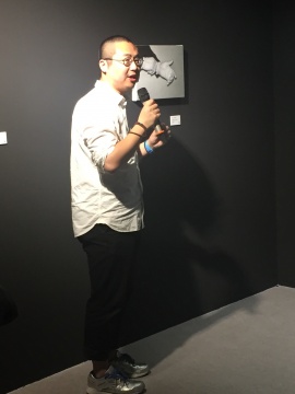 策展人杨西为大家导览“西安角项目首展——蔡龙飞：测试盒”，他头顶的作品为蔡龙飞原作《片段-2》
