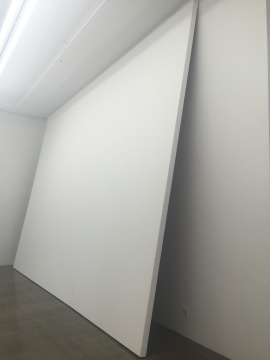 美术馆入口处前厅斜倚在墙面的巨大空白画布,其画框高度因超过空间高度不得不倾斜地紧紧顶住墙面顶端,尽管画布表面已经在工作室做过了专业画底处理,但在现场仍然将被涂上墙面涂料,这件作品名为《无题》,其动机试图挑战绘画的通常概念
美术馆入口处前厅斜倚在墙面的巨大空白画布,其画框高度因超过空间高度不得不倾斜地紧紧顶住墙面顶端,尽管画布表面已经在工作室做过了专业画底处理,但在现场仍然将被涂上墙面涂料,这件作品名为《无题》,其动机试图挑战绘画的通常概念