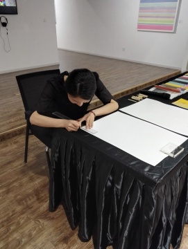 艺术家在开幕现场向观众展示书写“1”的创作状态 艺术家在开幕现场向观众展示书写“1”的创作状态