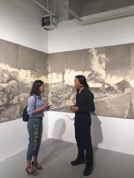 苏新平（右）在作品《荒原》前接受媒体采访
