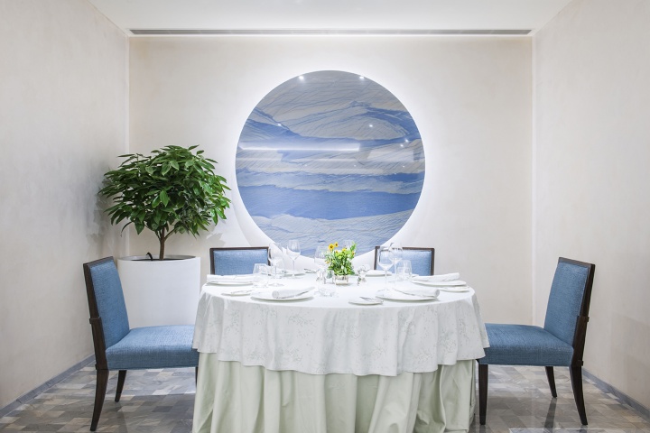 王府半岛酒店Jing餐厅一角，墙上的蓝白相间的作品与蓝椅子、白桌布相互印衬
