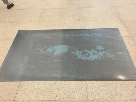 地面上的钢板作为屏幕，呈现了伍伟拍摄的视频
