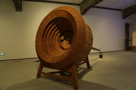 《井》 木、水，550x230x250cm，2010

这件作品是以福建土楼的建筑为形，这种建筑只有一个进出口，楼层环绕着圆形建筑而上，如树之年轮。这是一种部落的生活方式，大可以是一个村落，小可以是一个姓氏家族，在这楼院中心定有口井。
在作品的前部是土楼的模型，后部是由院中的井口延伸而出的一个树干，水顺树心而下滴落到另一端的一个黑色的小桶中，正是人们常用到井中取水的小桶…… 
