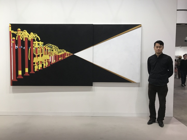 艺术家臧坤坤在他的作品前面
