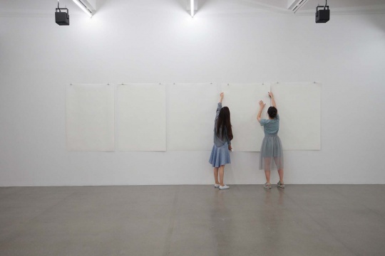 “菲利普·帕雷诺：共此时”三楼展厅，工作人员不定时更换墙面上的磷光死亡海报
