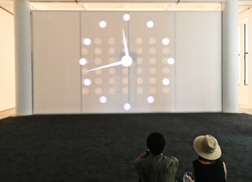 “菲利普·帕雷诺：共此时”二楼展厅，观众坐在地毯上静待影片《这世界以外的任何地方》的播放
