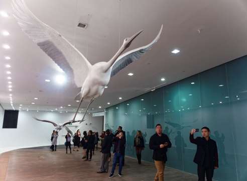 「天人之际·蔡志松艺术展」开幕式现场，观众从“起飞”的仙鹤下走过
