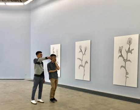 艺术家劳家辉（左）在介绍作品
