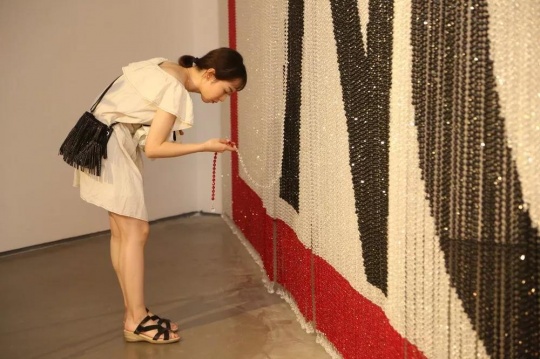 蔡雅玲的作品《No》主体是由黑、白、红三色串成的珠帘。观众从中穿过时将平静的珠帘打破，从这一由静至动的过程中获多重感官上的触动。
