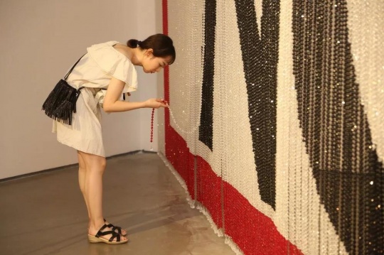 蔡雅玲的作品《No》主体是由黑、白、红三色串成的珠帘。观众从中穿过时将平静的珠帘打破,从这一由静至动的过程中获多重感官上的触动。
蔡雅玲的作品《No》主体是由黑、白、红三色串成的珠帘。观众从中穿过时将平静的珠帘打破,从这一由静至动的过程中获多重感官上的触动。