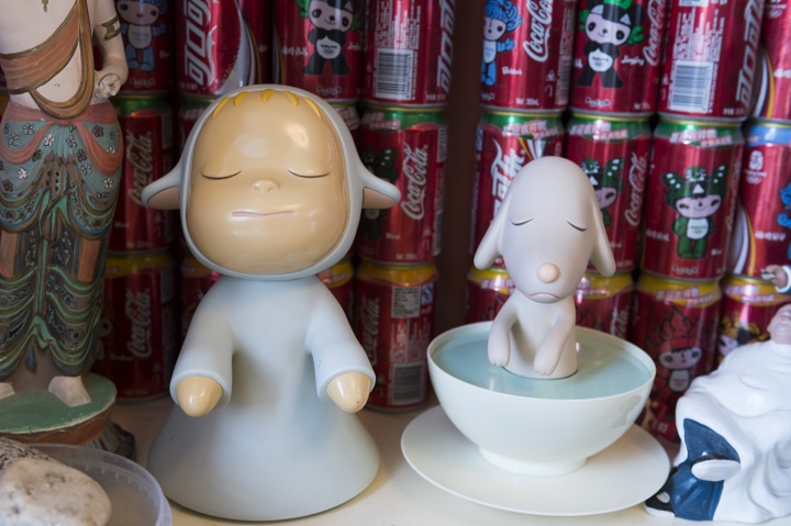 奈良美智的“梦游娃娃”和“梦游狗狗“，它们身后是罗小虎搜集的各种纪念版可口可乐
