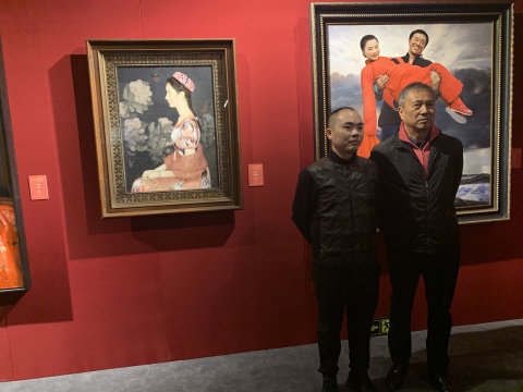 艺术家王沂东（右）与来宾在其作品前