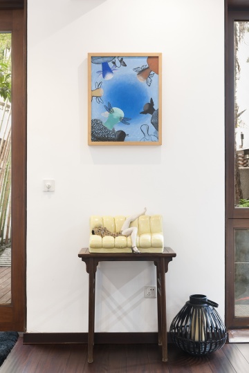 条案上摆放的是刘建华90年代末的“彩塑系列”《迷恋的记忆》，墙上挂的是李山2003年的布面水彩作品《无题》。
