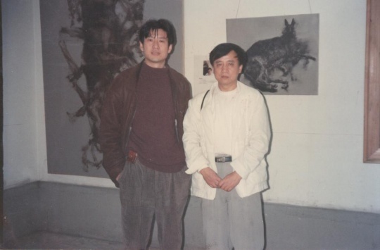 周春芽（左一）在其作品《黑根一家》与《躺着的黑根》之前，’96上海（美术）双年展展览现场，1996年。周春芽供图。
