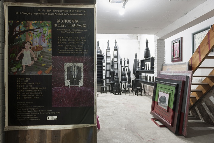 对面的那间工作室用来做展示，进门的柜子上还贴着2011年他和来自德国的“黄漂”艺术家小杨在器·Haus空间的双个展海报
