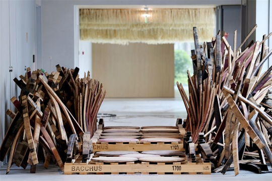 使用崃州蒸馏厂威士忌木桶盖及废拼板搭建的木桥所连接的两个展厅 使用崃州蒸馏厂威士忌木桶盖及废拼板搭建的木桥所连接的两个展厅