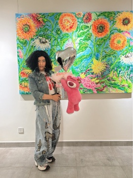 卢云手捧粉丝送的花束在自己作品前合影
Lu Yun holds a bouquet gifted by a fan and takes a photo in front of his own artwork.

